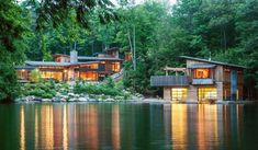 a house sitting on top of a lake surrounded by trees