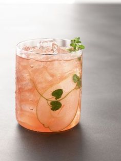 a close up of a drink in a glass with ice and garnishes