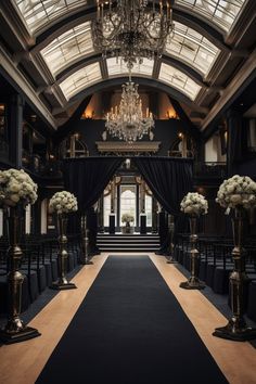 an ornate hall with chandeliers and black drapes on the ceiling is decorated with white flowers