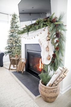 a fireplace decorated for christmas with stockings and pine cones