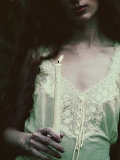 a woman holding a candle in her hands