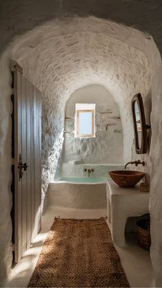 a bathroom with a sink, mirror and tub in the middle of an arched room