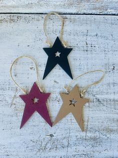 three wooden stars hanging from string on white wood