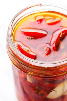 a jar filled with pickled peppers sitting on top of a table