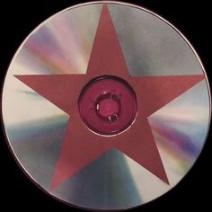 a red star on a silver disc with white and pink highlights in the center, as if it were from an album