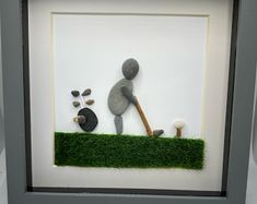 a shadow box with grass and rocks in it that has a man holding a golf club