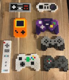 several different types of perler beads on a table with video game controllers in them