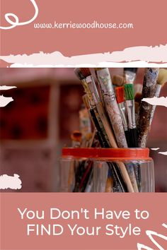 a jar filled with lots of paintbrushes on top of a table