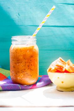 a glass jar filled with liquid next to a bowl of food