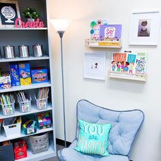 a blue chair sitting in front of a book shelf filled with children's books