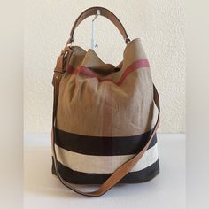 Burberry Ashby Shoulder Bag. Interior Comes With A Detachable Canvas Slip Pockets And A Zip Pocket With The Brand Logo. Exterior Is Made From Canvas, Features Leather Handle, Strap And Trims, Hook-Like Closure, Metal Fittings, Protective Feet Base. Condition: Interior Is Neatly Used, Creasing On Canvas, Mild Storage Odor, Scuff Marks, No Rip No Tear. Exterior Shows Used, Creasing On Canvas, Minimal Signs Of Aging On Leather, Scuff Marks, Roughness On Corner Edges, Hardwares Shows Scratches. H:13 Designer Hobo Bag With Detachable Strap For Errands, Burberry Bag, Hobo Bag, Leather Handle, Brand Logo, Zip Pockets, Burberry, Bag Lady, Shoulder Bag