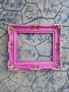 a pink frame sitting on top of a stone floor