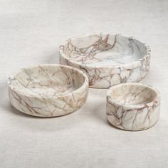 three white marble bowls sitting next to each other