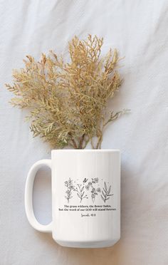 a white coffee mug with some plants in it