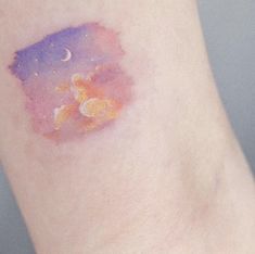 a small tattoo on the leg of a person with an orange and purple substance in it