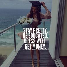 a woman in graduation cap and gown holding flowers on balcony with ocean view behind her