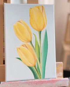 a painting of three yellow tulips on a canvas