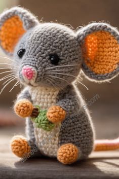 a crocheted mouse sitting on top of a wooden floor