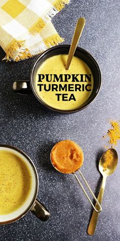 there is a cup of pumpkin turmeric tea next to two spoons