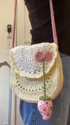 a crocheted purse with a strawberries decoration hanging from it's side