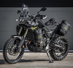 a black motorcycle parked in front of a garage