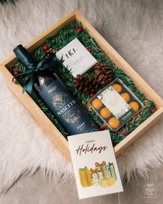 the holiday gift box contains two bottles of wine and an assortment of candies