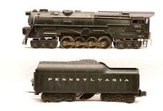 two model trains side by side on a white background and one is black with gold lettering