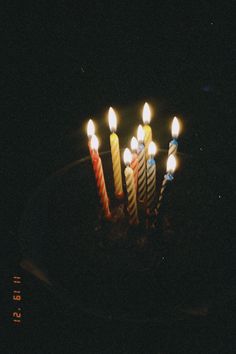 a birthday cake with lit candles on it