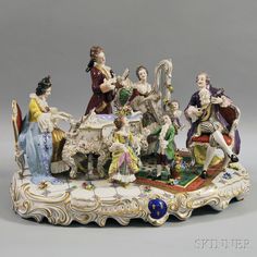 a group of porcelain figurines sitting on top of a white and gold table