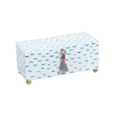 a white box with blue polka dots and a tassell on the lid,