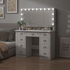 a white vanity with lights on it in a bedroom