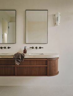 two mirrors are above the double sinks in this bathroom, while another mirror hangs on the wall