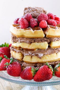 a stack of waffles with chocolate frosting and fresh strawberries on top