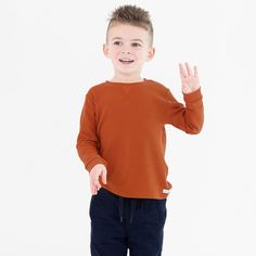 This rust waffle tee will keep your little guy cozy and looking cool all season long! Composed of soft waffle knit fabric, this is the perfect shirt to welcome in the autumn season. Pair with your favorite jean to keep your little guy warm while playing out in the fall leaves. Long Sleeve Waffle Knit Sweatshirt For Fall, Fall Waffle Knit Long Sleeve Sweatshirt, Brown Casual Tops With Ribbed Cuffs, Casual Brown Tops With Ribbed Cuffs, Casual Burnt Orange Sweater For Fall, Ribbed Cotton Sweatshirt For Everyday, Brown Tops With Ribbed Cuffs For Fall, Brown Top With Ribbed Cuffs For Fall, Casual Brown Sweatshirt For Everyday