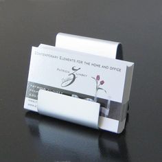 a business card holder sitting on top of a black table next to a computer mouse