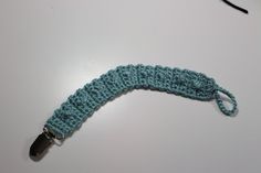 a blue crocheted umbrella with a black handle on a table next to a pair of glasses