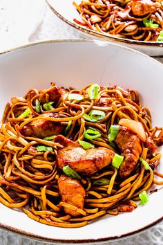 two white bowls filled with noodles and meat