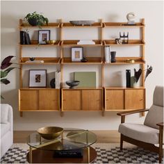 a living room filled with furniture and bookshelves next to a wall mounted shelf