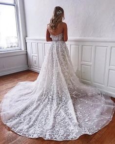 a woman in a wedding dress looking out the window