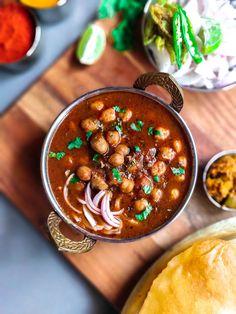 a bowl filled with beans and onions next to bowls of other food on a table