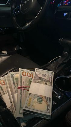 a bunch of money sitting in the center console of a car