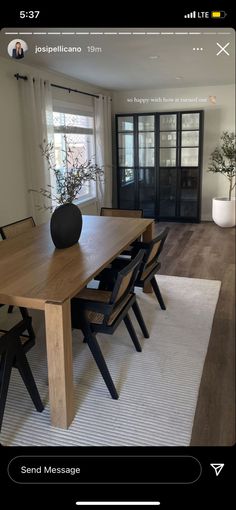 a dining room table with chairs and a vase on it