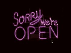 a neon sign that says sorry we're open