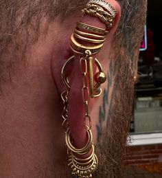 a man with piercings on his ear wearing gold jewelry