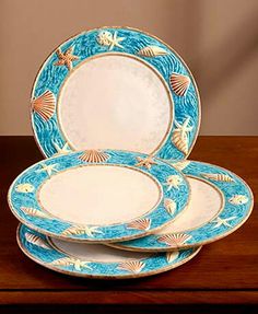 three blue and white plates sitting on top of a wooden table next to each other