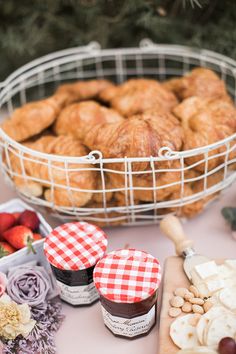 a table topped with lots of food and desserts next to a bowl of fruit