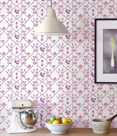 a bowl of fruit sitting on top of a wooden table next to a wallpaper