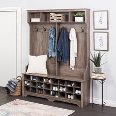 an entryway with a bench, coat rack and rug on the floor next to it