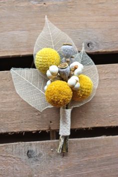 a boutonniere with yellow and white flowers attached to the side of a wooden bench