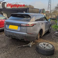 a car that is sitting in the dirt next to a tire and some other cars